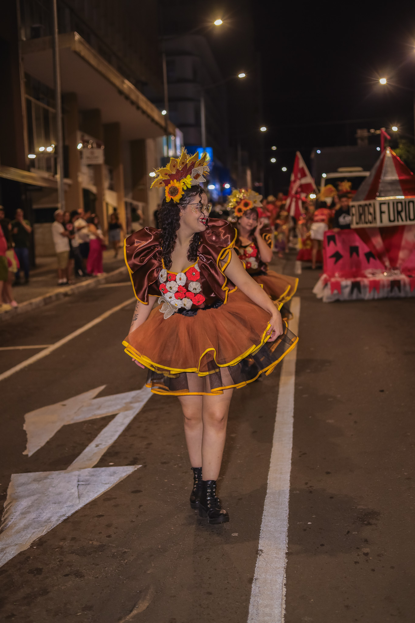 Passista de escola de samba em movimento, com fantasia colorida